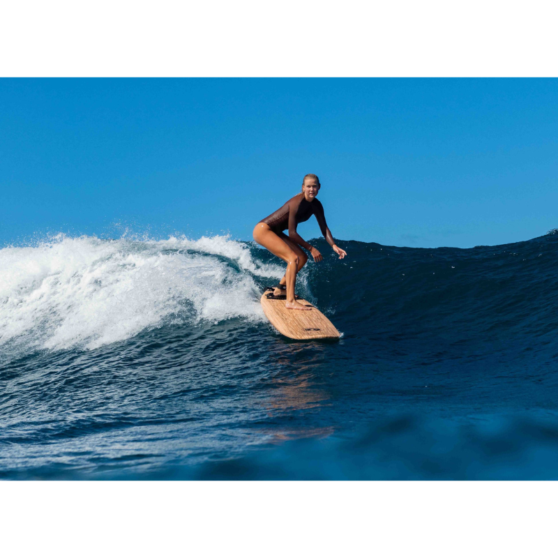 Woman surfing on Classic Wood Graphic Foam Surfboard 